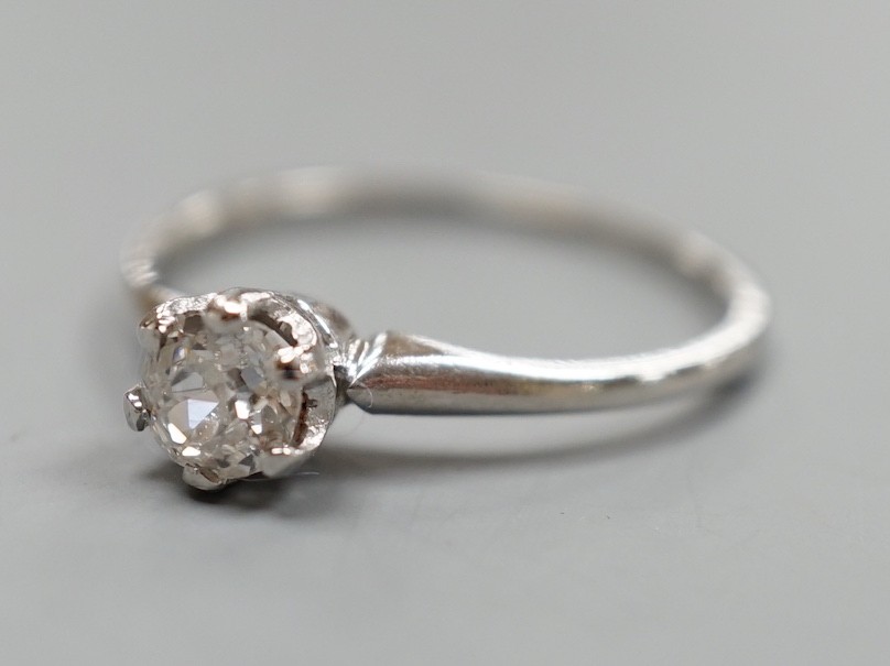 A white metal (stamped plat) and solitaire diamond ring, size O, gross weight 2.3 grams.